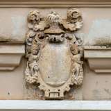 ...sormontato da una balaustra in pietra bianca con lo stemma dei Damiani
